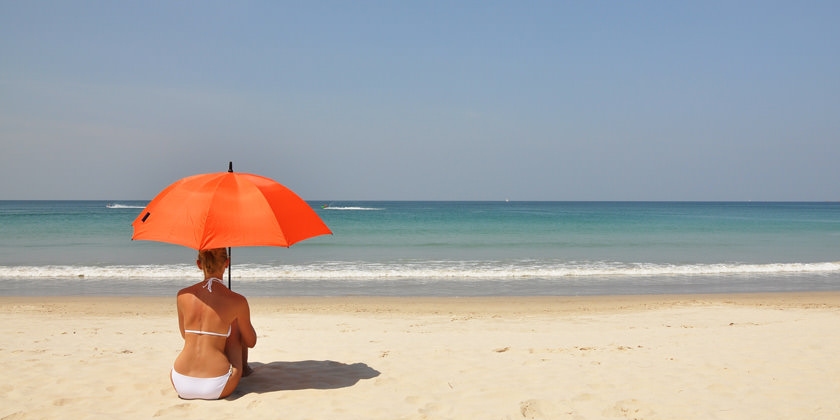Mujer en la playa con una sombrilla