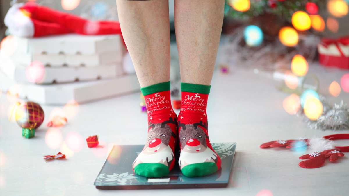Mujer con calcetines navideños pesándose