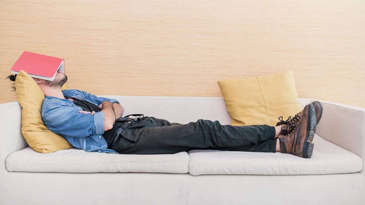 Un hombre echándose la siesta en el sofá